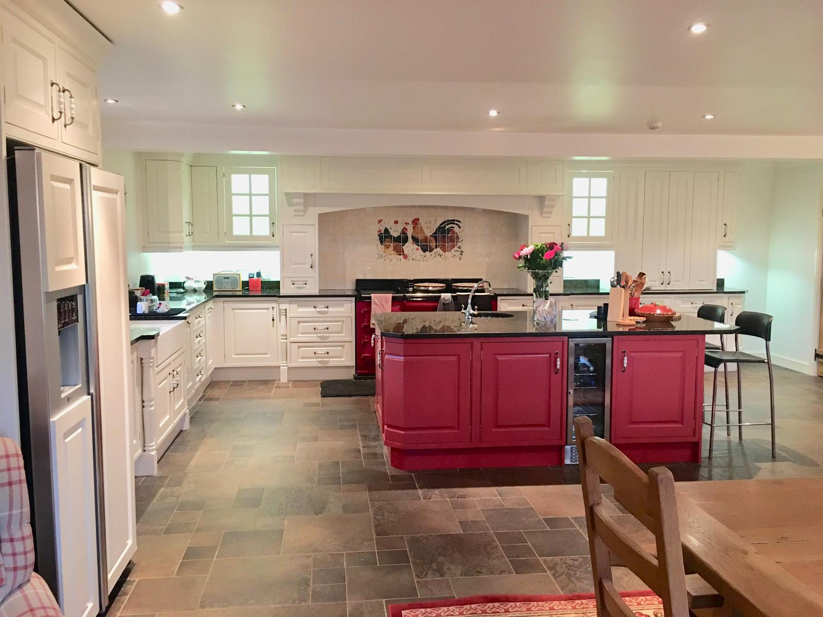 Large bespoke kitchen hand painted in Farrow and Ball pointing on the main cabinets and Farrow and Ball Radicchio Red on the island